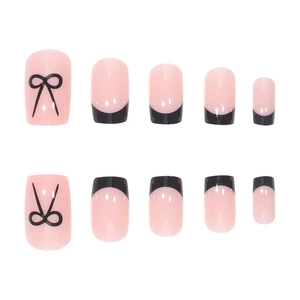 Pink and black French press-on nails with bow design on a minimalist white background