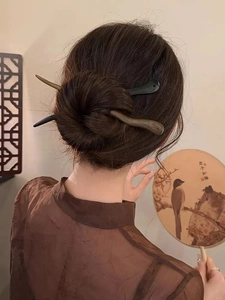 Détail de pics à cheveux en bois de santal coiffant un chignon élégant de style chinois