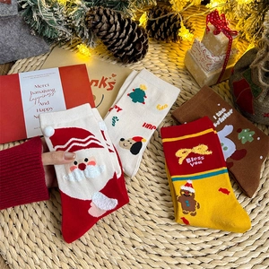 Christmas cartoon crew socks set with Santa and reindeer motifs on straw mat