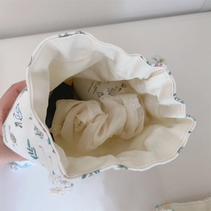 Gros plan de l'intérieur du sac à cordon en toile fleurie montrant l'espace de rangement