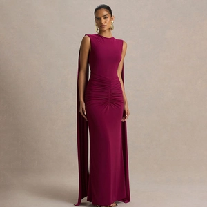 Dettagli di un elegante abito da sera magenta con maniche a mantella e drappeggio