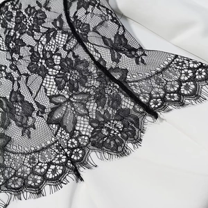Detail of black lace dress showing delicate eyelash lace edge and transparent floral mesh