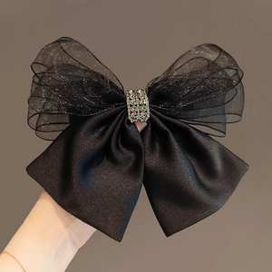 Large black mesh bow hair clip with satin layers and a sparkling rhinestone center buckle