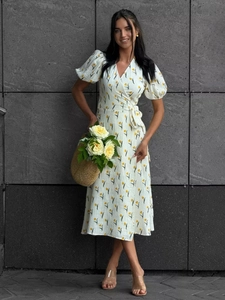 Detail of white cotton floral dress with puffed sleeves and a waist tie wrap design
