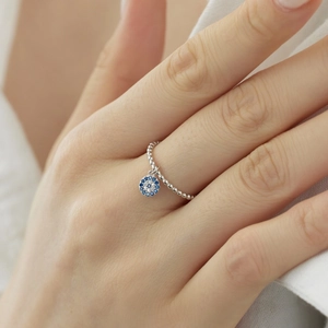 Close-up of S925 sterling silver beaded ring featuring a blue evil eye charm on finger