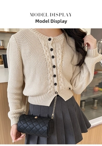 Detail of beige cable-knit cardigan with contrasting black buttons and vintage texture