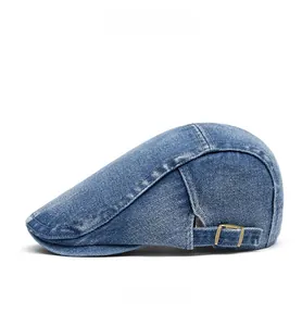 Side view of washed blue denim beret hat with adjustable metal buckle detail