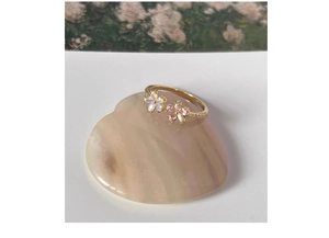 Macro shot of gold S925 silver flower ring with pink crystals on pink stone base