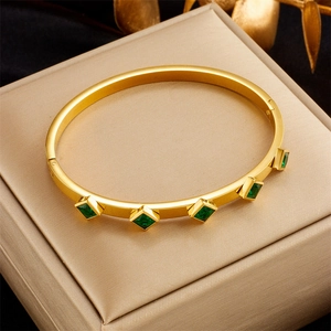 Golden titanium steel bangle with five square green emerald-like stones on silk