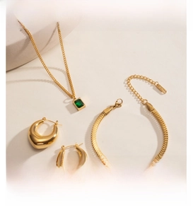 Three-piece jewelry set with emerald zircon pendant, chunky hoop earrings and scale bracelet