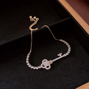 Detail of gold-plated key bracelet with zircon inlay on a black velvet jewelry box