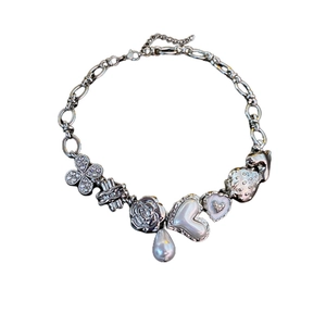 Silver chain necklace featuring clover, heart, strawberry, and pearl charms with rhinestones