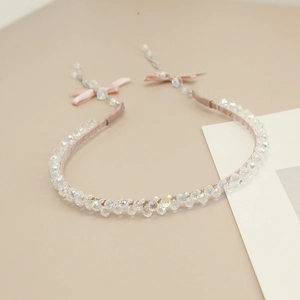 Detail of pink woven headband with iridescent crystal beads and small bow accents