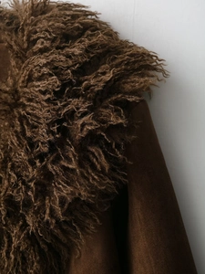 Detail of dark brown curly faux fur collar and matte faux suede texture on jacket