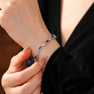 Detail of vintage palace style silver bracelet with oval blue zircons and crystals