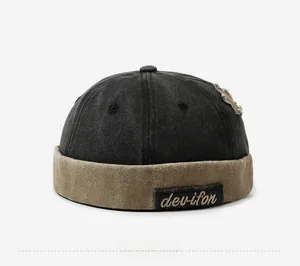 Detail of vintage patchwork docker hat with embroidery and distressed fabric texture
