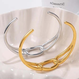 Minimalist open gold and silver bangles with interlocking chain link design on shell tray