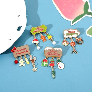 Detail of Christmas enamel pins with Santa and snowman charms and hanging pearls