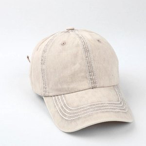 Detail of contrast white triple stitching on beige cotton baseball cap brim