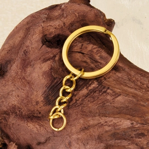 Polished 18K gold plated stainless steel key ring with short link chain on wood surface