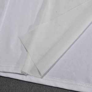 Gros plan détaillé sur la texture du tissu blanc et les coutures de l'ourlet de robe