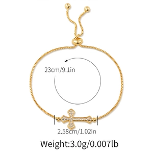 Macro view of gold-plated cross bracelet with white rhinestones and size dimensions
