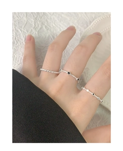Close-up of minimalist S925 sterling silver stacked rings with black zircon on hand
