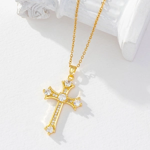 Elegant gold titanium cross pendant necklace with white zircon pavé on a minimalist background