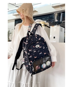 Detail of black canvas backpack with dachshund print and transparent front pocket