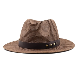 Détail d'un chapeau de paille marron foncé avec bande en cuir et rivets dorés