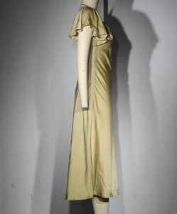 Détail de la robe en satin champagne montrant les manches à volants et la texture soie