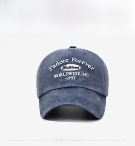 Detailed view of white letter embroidery on a blue washed denim vintage baseball cap