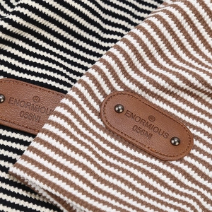Close-up of retro plaid knit fabric textures with premium brown leather logo patches