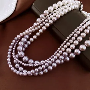 Elegant multilayer pearl necklace with gradient white to purple pearls on silk fabric