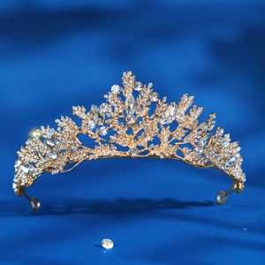 Close-up of golden bridal tiara with sparkling crystal rhinestones on blue background