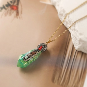 Close-up of green natural crystal pendant with black base and multi-color rhinestones