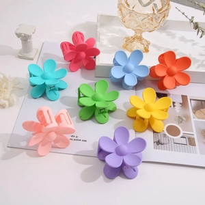 Flat lay of large matte candy-colored flower hair claws in a variety of macaron shades