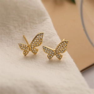 Macro shot of 18K gold plated bow earrings with sparkling rhinestones on soft fabric