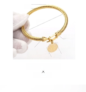 Detailed view of golden twisted cable bracelet with St. Benedict medal and 60mm diameter