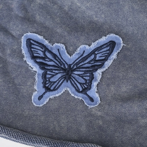Retro knit beanie in washed blue featuring a frayed butterfly patch for a vintage style