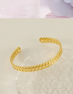 Vue détaillée du bracelet ouvert en acier inoxydable plaqué or 18k avec texture de chaîne