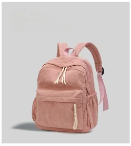 Detailed front view of pink corduroy backpack featuring texture and woven zip puller
