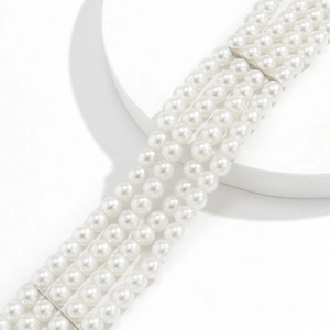 Close-up of four-row stacked pearl choker with elegant cream-colored beads and metal spacers
