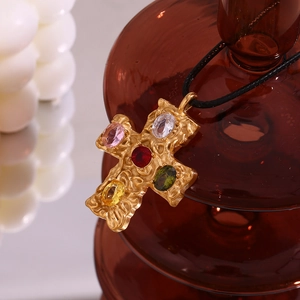 Detail of 18K gold-plated cross pendant with five colorful gemstones on a black rope