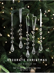Macro detail of transparent acrylic icicle pendants hanging on a Christmas tree branch