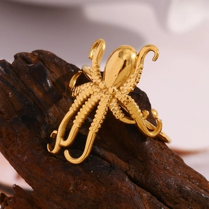 Macro shot of 18K gold octopus ring with detailed tentacle texture on dark wood
