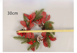 Detail of 30cm Christmas wreath with pine cones and red berries measuring with a tape