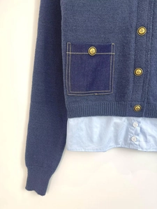 Détail du cardigan en maille bleue avec poches en denim et boutons dorés élégants