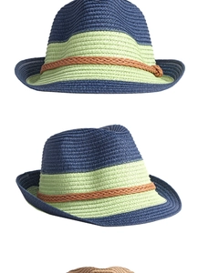Detail of color-blocked straw sun hat with navy and green weave and brown ribbon