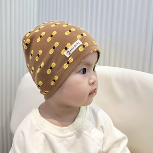 Brown cotton knit baby hat with yellow bee pattern shown in a warm side-view profile
